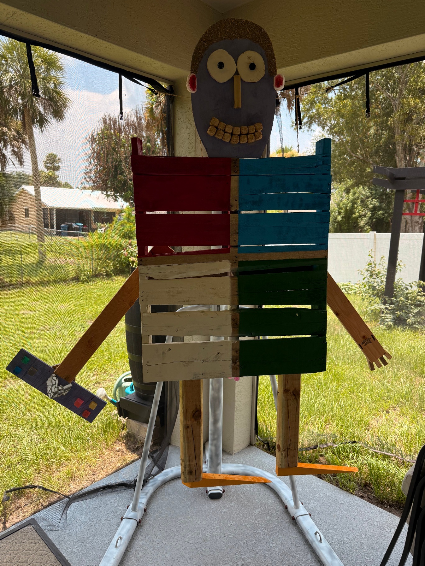 Wooden figure sculpture holding a paint palette