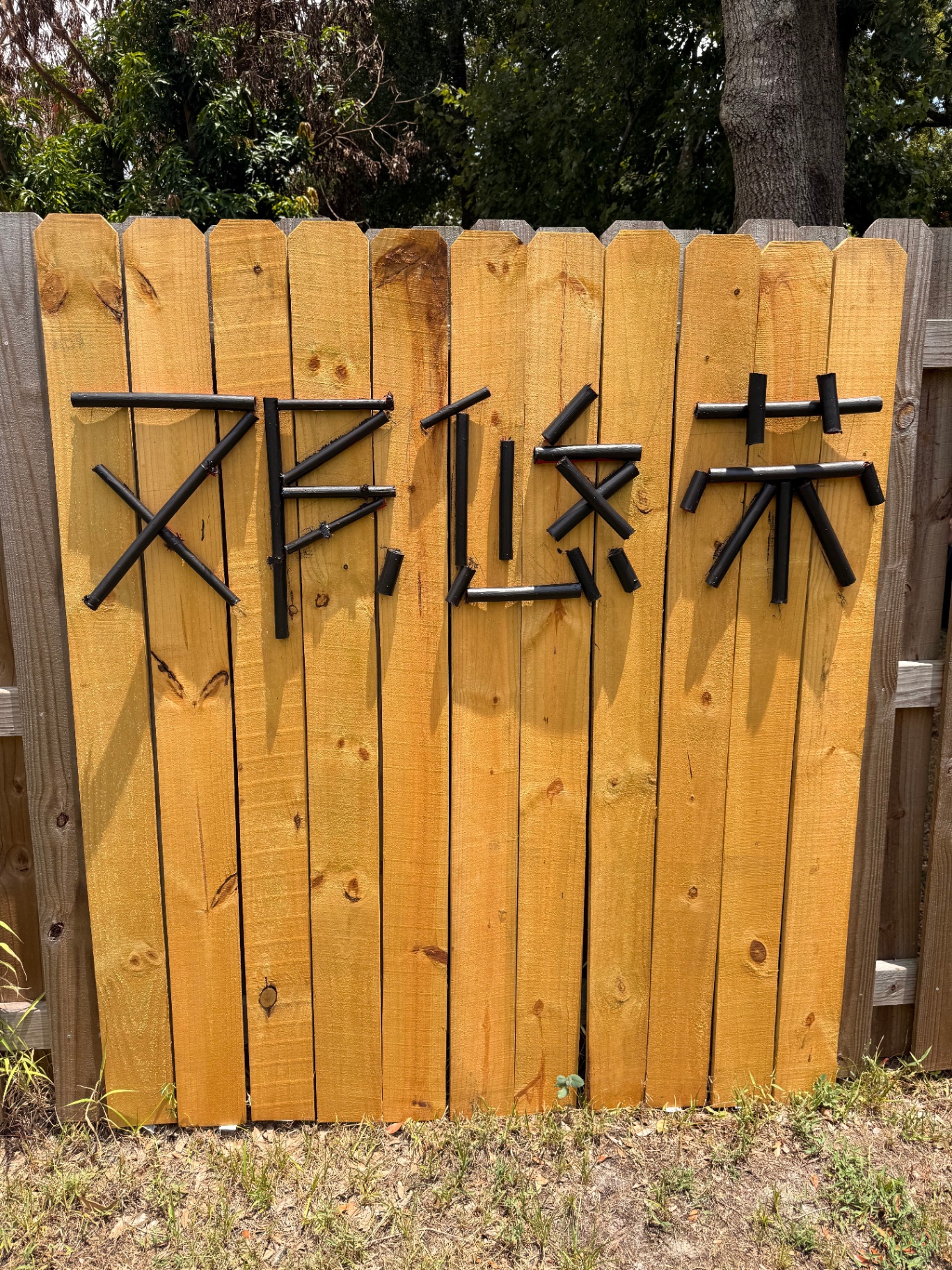 Chinese characters made of painted wood on a fence